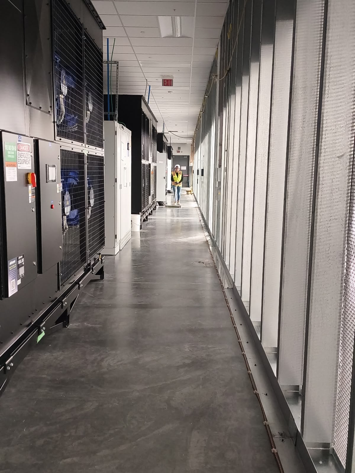 Technician walking an operating data center equipment aisle during scheduled cleaning